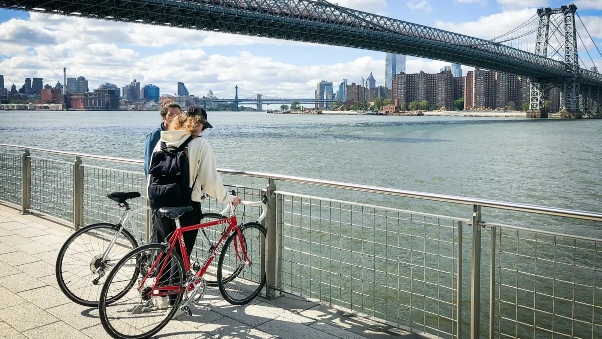 Two cyclists stopped looking out at East River