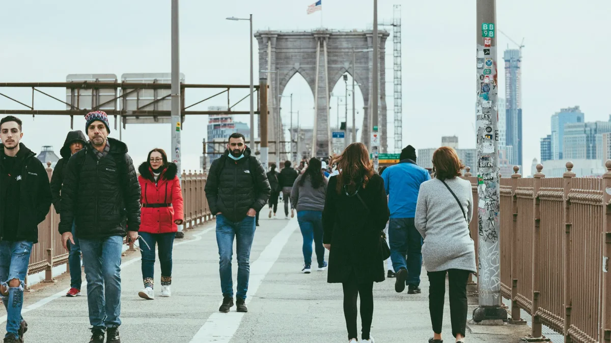 People walking on Brooklyn Bridge in winter